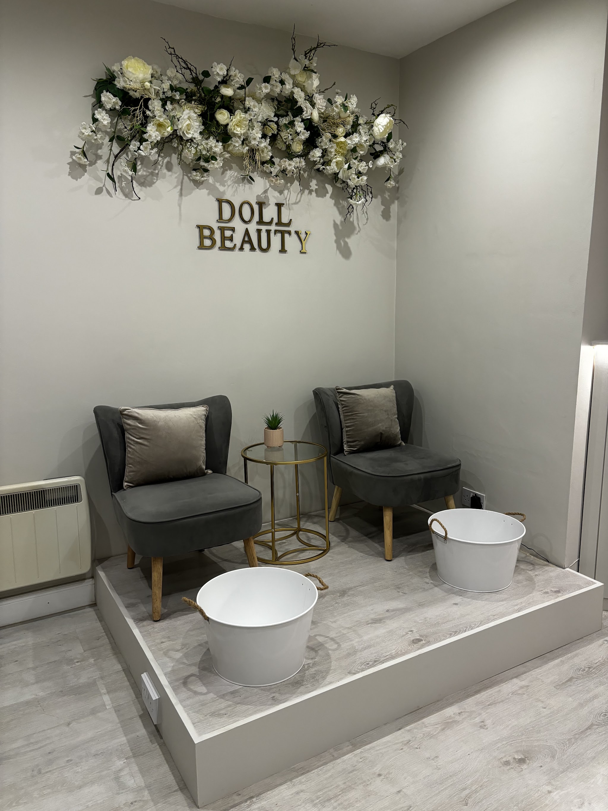 The salon’s pedicure chairs beneath flowers and the Doll Beauty sign