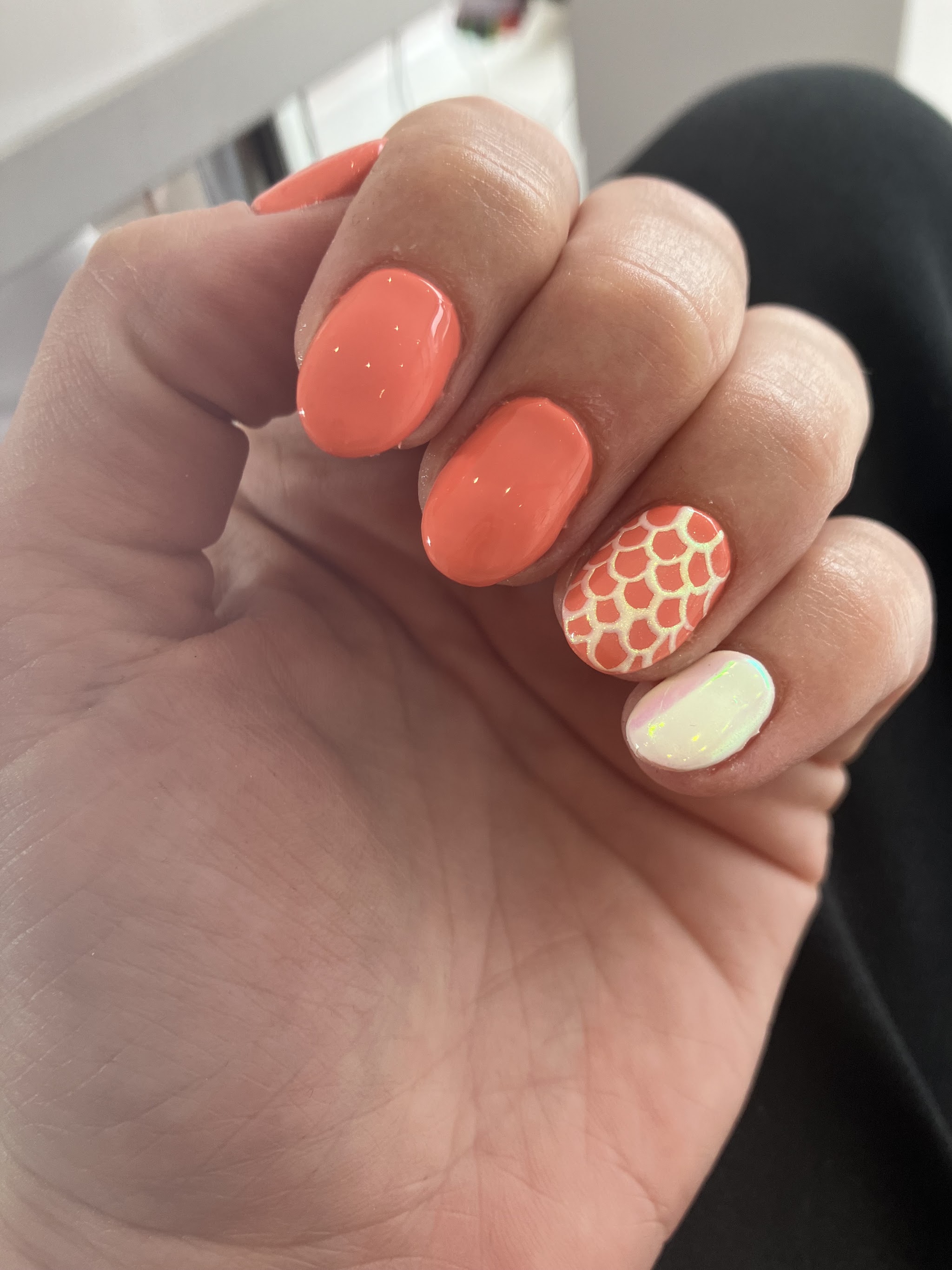 Coral manicure with a shimmering patterned accent nail